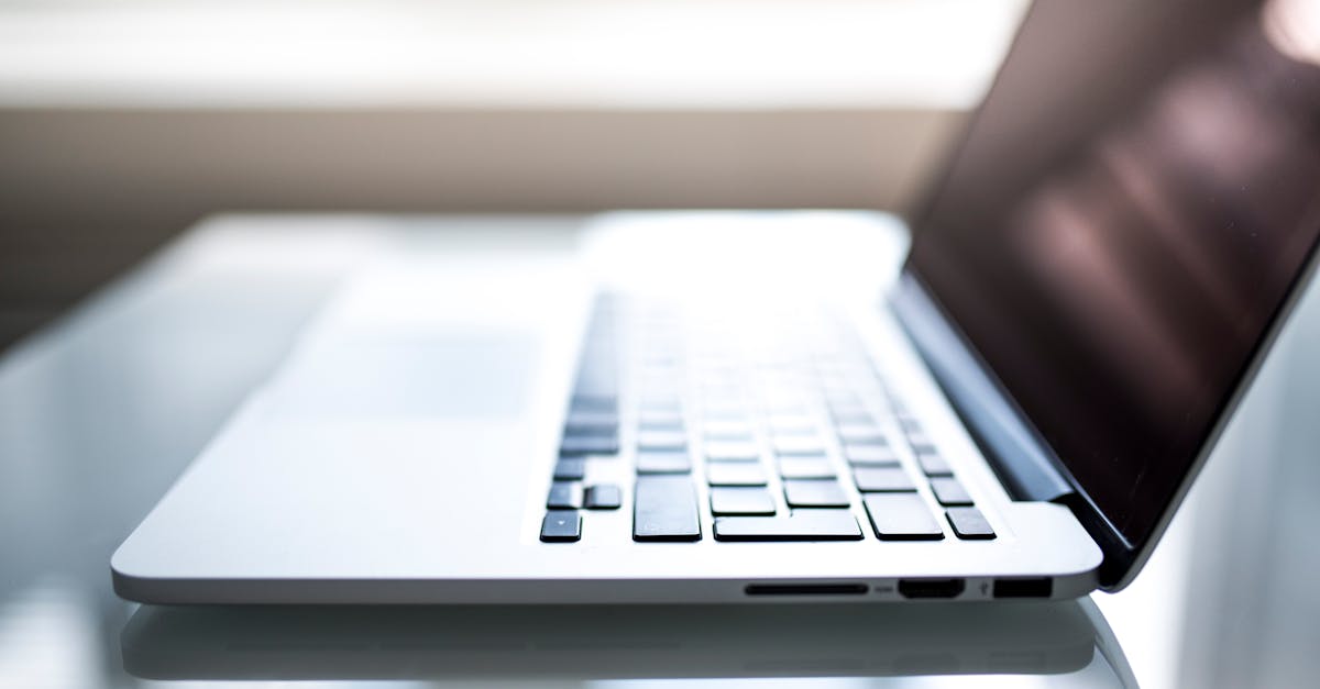 Elegant side view of a laptop on a glossy table with natural lighting indoors.